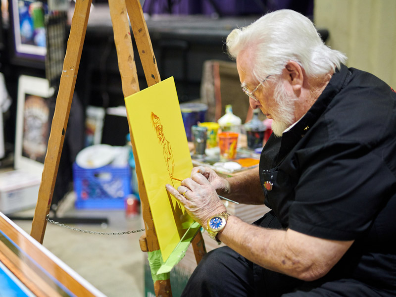 Man painting item at the Pinstriper Charity fund raiser