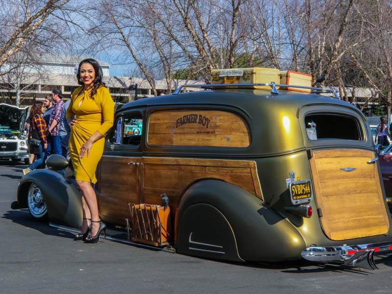 Female model posing next to classic car